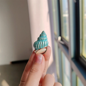 Spilla creativa a forma di conchiglia blu con base dorata, occhio di gatto e cristalli lucenti