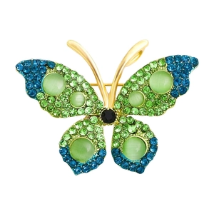 Glinsterende vlinderbroche met groene en blauwe kristallen op een gouden metalen basis