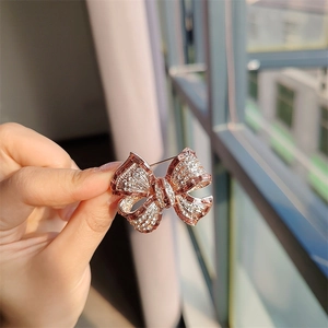 Vue détaillée d'une broche nœud en or rose ornée de zircons cubiques scintillants