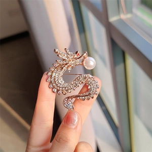 Lussuosa spilla a forma di drago in oro rosa con strass scintillanti e grande perla bianca