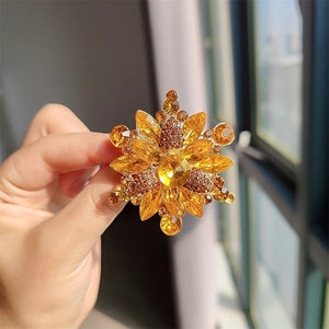 Primer plano de un broche de copo de nieve con gemas ámbar y base de metal dorado