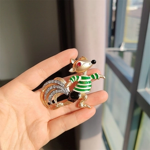 Detailed close-up of a vintage squirrel brooch with green enamel and sparkling rhinestones