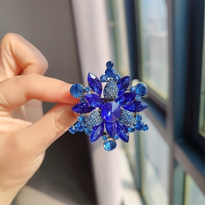 Primer plano de broche vintage de copo de nieve con cristales azules y acabado dorado
