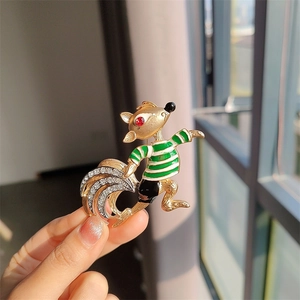 Detail of vintage squirrel brooch featuring green enamel stripes and sparkling crystals