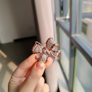 Gros plan détaillé d'une broche nœud en or rose ornée de strass blancs brillants