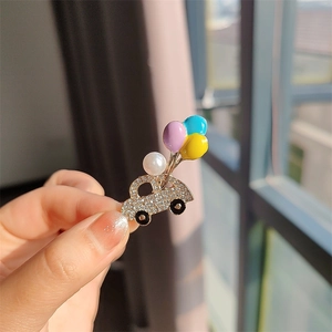 Gros plan d'une broche camion avec ballons colorés et strass blancs brillants