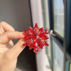 Vista detallada de un broche floral vintage con cristales rojos marquesa sobre base dorada