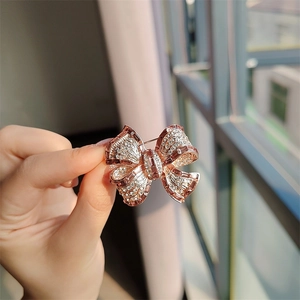 Détail d'une broche nœud en or rose sertie de cristaux brillants avec fermoir épingle