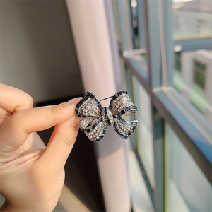 Détail macro de la broche nœud en argent sertie de zircones et de pierres bleu foncé