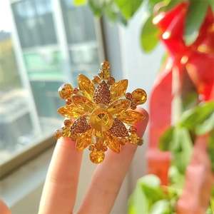 Broche de flor vintage dorado con pedrería de ámbar y pétalos de cristal geométricos