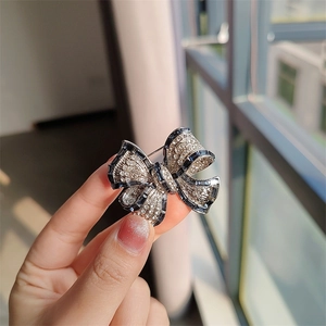 Vue détaillée d'une broche nœud argentée ornée de zircons et de pierres bleues