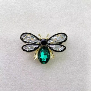 Vintage bee brooch with green crystal and sparkling rhinestones on golden metal