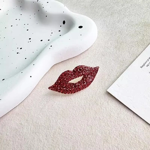 Vintage style red lip brooch with micro-set zircons on a stylish minimalist background