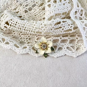 Broche fleur de gardénia avec pétales en émail blanc et perles sur fond de dentelle