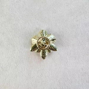 Vue arrière de la broche fleur de gardénia dorée avec fermoir papillon sécurisé