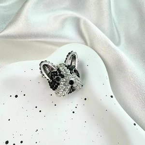 French Bulldog dog brooch with sparkling crystals on a white porcelain dish and silk background