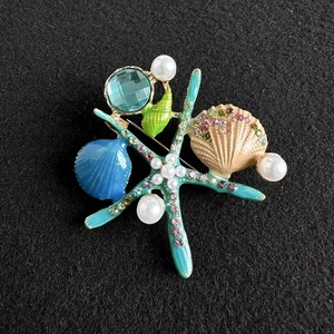 Broche marine avec étoile de mer, coquillage, cristal bleu, perles et strass colorés
