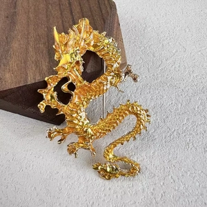 Exquisite goldene chinesische Drachenbrosche mit feinen Schuppen auf Texturhintergrund
