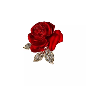 Broche fleur rose rouge exquise avec feuilles dorées et cristaux étincelants sur fond blanc
