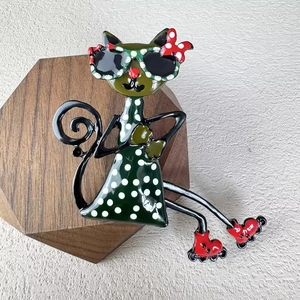 Fashionable cat brooch with sunglasses and red roller skates on a wooden display
