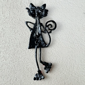 Detailed back view of a black cat brooch showing the metal pin and durable alloy structure