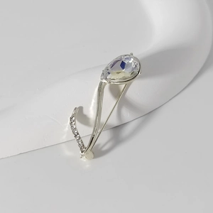 Détail macro d'une broche note musicale de luxe avec strass goutte et fini argenté