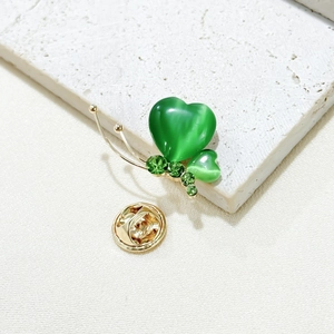 Exquisite gold butterfly brooch featuring green heart-shaped opal wings and crystals