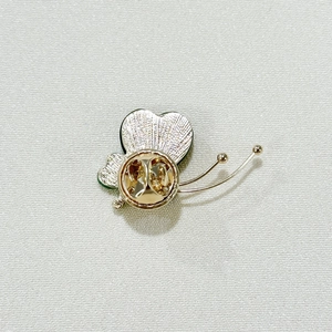 Detailed back view of a golden butterfly brooch with secure clasp and textured wings