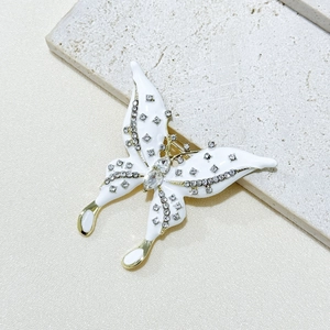 Elegant butterfly brooch with white enamel, gold plating and shimmering rhinestones