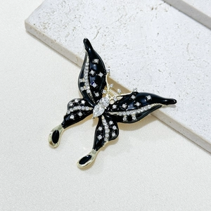 Elegant butterfly brooch with black enamel and sparkling rhinestones on gold metal