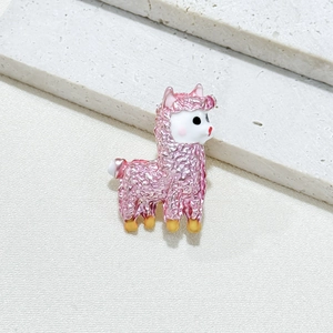 Pink alpaca brooch with fine glazed texture and golden hooves on white stone