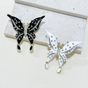 Elegant butterfly brooches with rhinestones and enamel on a minimalist stone display