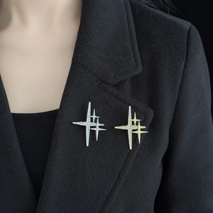Elegant gold and silver star brooches with rhinestones on a black coat lapel