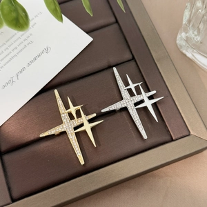 Elegant gold and silver star brooches with sparkling crystals on a leather display