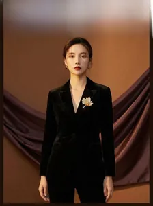 Detailed view of luxury maple leaf brooch with crystals on black velvet blazer lapel