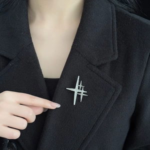 Elegant multi-star brooch with sparkling rhinestones pinned on a black wool coat collar