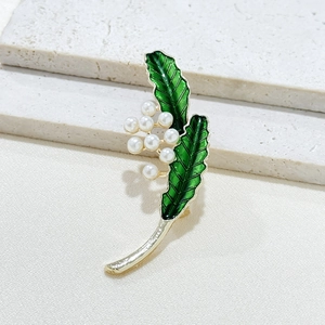 Broche vintage avec feuilles en émail vert et perles blanches sur base dorée