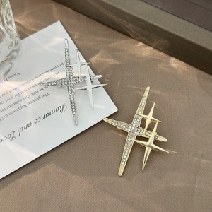 Detailed view of gold and silver starburst brooches with sparkling white crystals