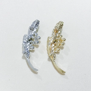 Détail de broches plumes en émail vintage en or et argent avec une surface texturée chic