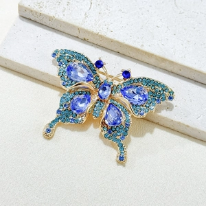 Detailed close-up of butterfly brooch with blue crystals and gold-plated alloy wings