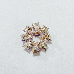 Detailed back view of a double-layer circular brooch with gold metal and safety pin clasp