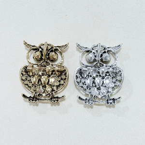 Detailed back view of owl brooch showing secure metal pin clasp and textured finish