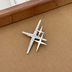 Detailed close-up of a North Star brooch featuring pavé rhinestones and silver polished stars