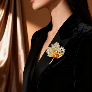 Luxurious maple leaf brooch with orange crystals and rhinestones on black velvet blazer