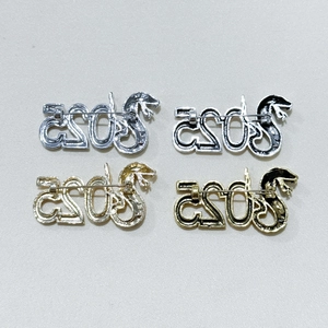 Detail of 2025 Snake Year brooches in gold and silver finish with enamel details