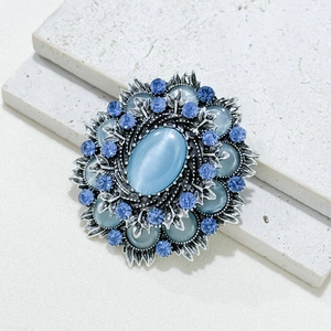 Barocke Brosche mit blauem Katzenaugenstein, funkelnden Strasssteinen und silbernem Laub