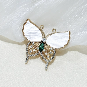Detail of emerald butterfly brooch with mother-of-pearl wings and crystal accents