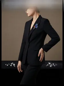 Élégante broche papillon bleue avec pierres précieuses sur un blazer noir chic