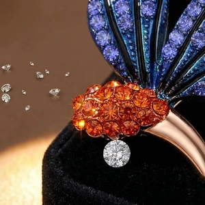 Élégante broche papillon en pierres bleues et diamant sur un support en velours noir