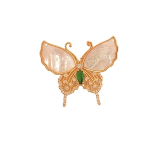 Elegant gold butterfly brooch with natural shell wings and a green emerald gemstone